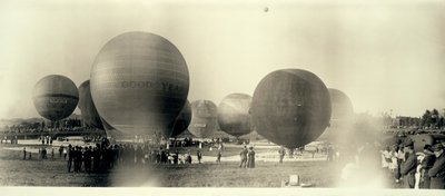 Heißluftballons auf einem Feld in Süd-St. Louis startbereit; einer ist bereits in der Ferne am Himmel von W.C. Persons