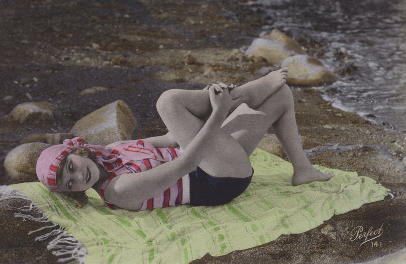Mädchen liegt auf Handtuch am Strand von English Photographer