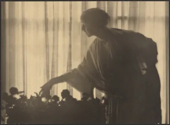 Frau pflegt Blumen in ihrer Wohnung