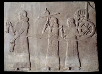 Hof des Palastes des assyrischen Königs Sargon II (721 - 705 v. Chr.) Diener tragen die Situlen und den Streitwagen des Königs. Paris, Louvre Museum