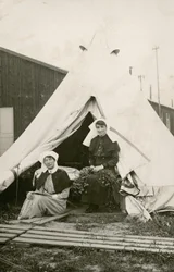 Schwester Eleanor Wibmer Jeffries und Schwester Nellie Constance Morrice (rechts) vor ihrem Zelt im No 3 Australian General Hospital mit Blumen, die vom Ufer der Somme gepflückt wurden, ca. Juni 1917 (s/w Foto)