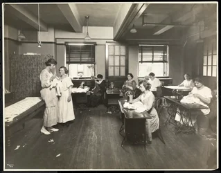 Blinde junge Frauen und eine Lehrerin beim Nähen in einem Klassenzimmer der New York Association for the Blind, 111 East 59th Street, New York, 1921