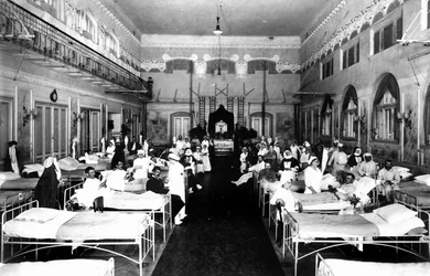 Dekorierter Salon in einem Krankenhaus mit Kriegsverwundeten und Rotkreuzschwestern