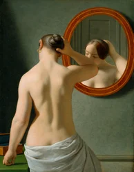 Eine nackte Frau, die sich vor einem Spiegel die Haare macht