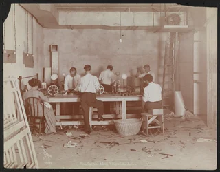 Filmlabore bei der Carlton Motion Picture Co. mit fünf Männern und einer Frau bei der Arbeit mit Film, Spleißen usw., New York