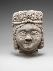 Kopf einer Figur mit Perlenkopfschmuck
