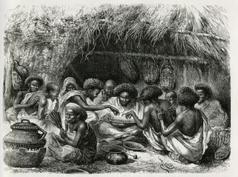 Toilette des Kaffees, die Frau mit dem Fächer aktiviert das Feuer, das die Kaffeebohnen erhitzt