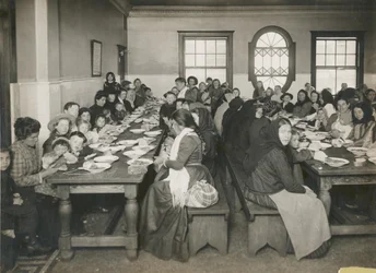 Einwanderer erhalten eine kostenlose Mahlzeit auf Ellis Island, um 1906 (s/w Foto)
