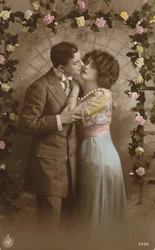 Paar steht unter einem Rosenbogen