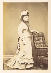 Japanische Frau in europäischer Kleidung, Ganzkörper-Studio-Porträt einer jungen japanischen Frau in westlicher Kleidung und Hut, Fotograf: Unbekannt, Lucas Sammlung: Fotografischer Bericht der Weltreise von Charles James und Morton P, Lucas