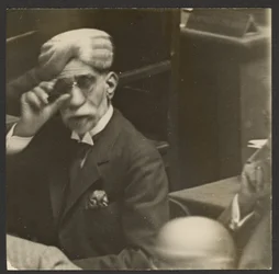 [Sitzender Mann mit Turban und dunkler Brille]