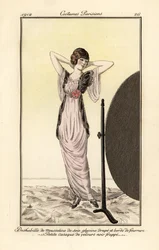 Frau im lila Musselin-Seidenkleid mit schwarzer Samtweste, die sich im Spiegel betrachtet. Deshabille de mousseline de soie glycine drape et borde de fourrure, petite casaque de velours noir frappe. Handkolorierter Pochoir (Schablonen) Stich nach einer Ill