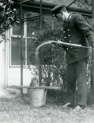 Wärter Thomas Raggett gibt einem Eulenschwalm eine Dusche, London Zoo, 1924