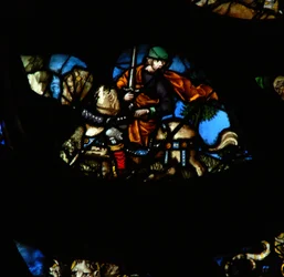 Das westliche Rosenfenster zeigt eine Szene aus dem Buch der Offenbarung: Ein Mann auf einem anderen Pferd (nicht rot, wie im Text) mit einem Schwert, um den Frieden von der Erde zu nehmen (6:4).