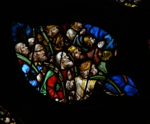 Das westliche Rosenfenster zeigt eine Szene aus dem Buch der Offenbarung: Menge vor dem Thron Gottes, in weißen Gewändern, die Palmen tragen (7:9-12). (weiße Gewänder sind hier etwas gefärbt!)
