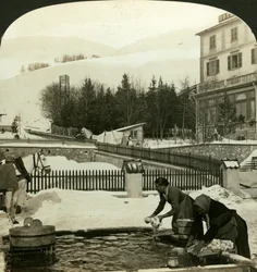 Frauen waschen Kleidung am öffentlichen Brunnen im tiefsten Winter, Zuoz, Schweiz