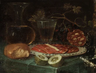Stillleben mit Brotstück, Glaskaraffe, Weinglas, Platte mit Schinken und Schinkenwurst, Zitrone und Messer mit Perlmuttgriff