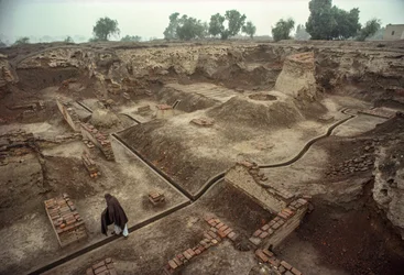 Übersicht über eine Grube, die mit den Überresten von Ziegelmauern und einem Ziegelbrunnen gefüllt ist. HARAPPA E...