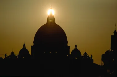 Sonnenuntergang hinter der Kuppel des Petersdoms. PETERSDOM, VATIKANSTADT.