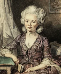 Eine junge Dame, sitzend an einem Tisch mit einem Buch