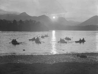 Eine Ansicht von Menschen, die auf Derwentwater Kanu fahren, entweder bei Sonnenaufgang oder Sonnenuntergang