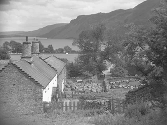 Bauerngebäude mit Schafen im Hof und Ullswater im Hintergrund