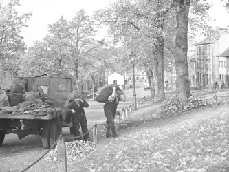 Lkw auf der Straße mit zwei Kohlenmännern, die Kohlesäcke tragen