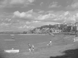 Menschen spielen in Booten bei Hochwasser in Arnside mit Albion Hotel im Hintergrund