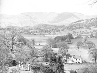 Drei Frauen stehen und blicken über einen See bei Esthwaite, Hügel im Hintergrund