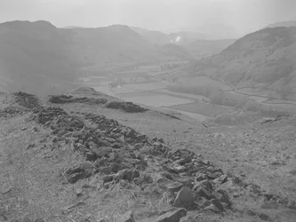 Blick über ein offenes Tal bei Hardknott mit Steinhaufen im Vordergrund