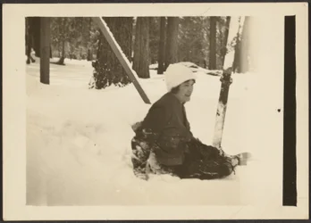 Frau, die im Schnee sitzt