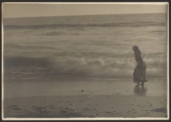 [Frau beim Spaziergang in der Brandung am Strand]