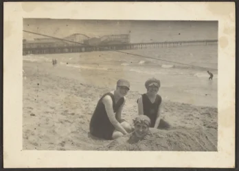 [Frauen am Strand begraben eine Freundin im Sand]