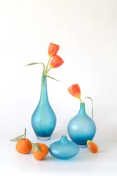 Orangefarbene Tulpen und blaue Vasen