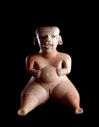 Präkolumbische Kunst, Maya-Zivilisation, präklassische Periode: Tonstatuette, die eine sitzende Frau mit geschwollenem Bauch und gespreizten Beinen darstellt (Gebärende?). Aus Kaminaljuyu, Guatemala. Guatemala, Museo Nazionale di Archeologia e Etnologia