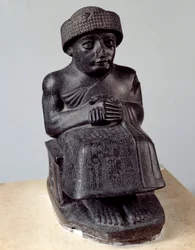 Mesopotamien: Statue des Gottes Ningischzida, die den sitzenden Gudea, Fürsten von Lagasch, darstellt. Neusumerische Zeit (ca. 2150-2000 v. Chr.). Paris, Louvre