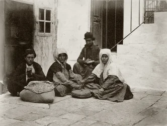 Frauen mahlen Mehl mit runden Mühlsteinen in einem Hof eines Hauses in Jerusalem (1867)