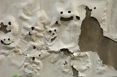 Italien, Toskana, Florenz, lächelnde Geistergesichter auf verwitterter bemalter Wand, 2022 (Foto)