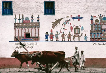 Gemaltes Wandbild auf einer Stuckwand eines Bauernhauses in Luxor erinnert an die frühen Jahre des Bauern