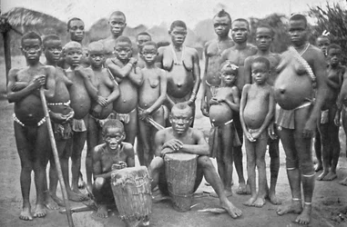 Bambute-Pygmäengruppe mit zwei Walese-Frauen, 1902