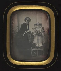 Kind auf einem Stuhl stehend und Blumen haltend, mit Mutter, um 1855
