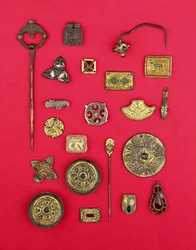 Sammlung von angelsächsischem und keltischem Schmuck, darunter vergoldete Bronzebeschläge, Untertassen- und Kreuzfibeln und ein merowingisches Anhänger, aus dem 1. bis 7. Jahrhundert n. Chr.