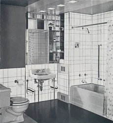 Crane Co. - Eine kompakte Nische, gefliest in Kanariengelb, mit Orange eingeritzt, zeigt den Edelstahl