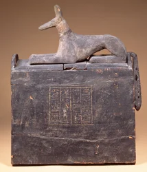 Pylonförmige Schabti-Box mit einer Inschrift und einer Statue von Anubis als Schakal (späteres Datum) auf dem Deckel, Ägyptisch, aus Theben, frühe 22. Dynastie, ca. 900 v. Chr.
