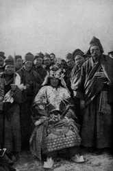 Tibet. Magier in voller Montur und eine bewundernde Gruppe von Mönchen. 1920