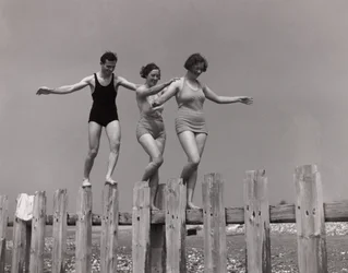 Zwei Frauen und ein Mann gehen entlang einer Buhne, ca. 1930er