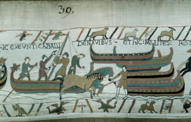 Eroberung Englands durch den Herzog der Normandie Wilhelm den Eroberer (1027-1087) im Jahr 1066: Normannische Schiffe segeln an der englischen Küste. Das Pferd zieht das Boot auf dem Flur. Detail des Teppichs von Bayeux oder der Stickerei von Königin Mathi