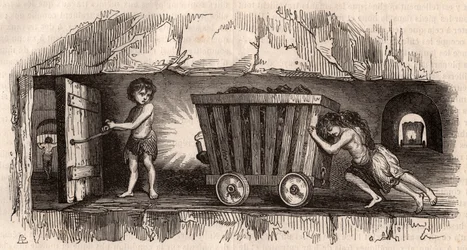Zwei Kinder schieben einen Wagen in einer englischen Kohlenmine, ein drittes, der Trapper, öffnet eine Tür