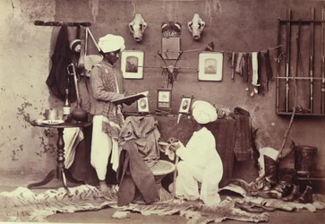 Zwei indische Diener in einem arrangierten häuslichen Interieur, aus der 